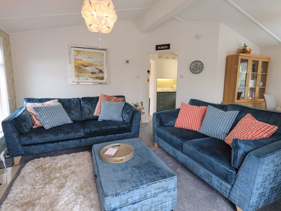 A living room with blue sofas and a coffee table at Charnwood