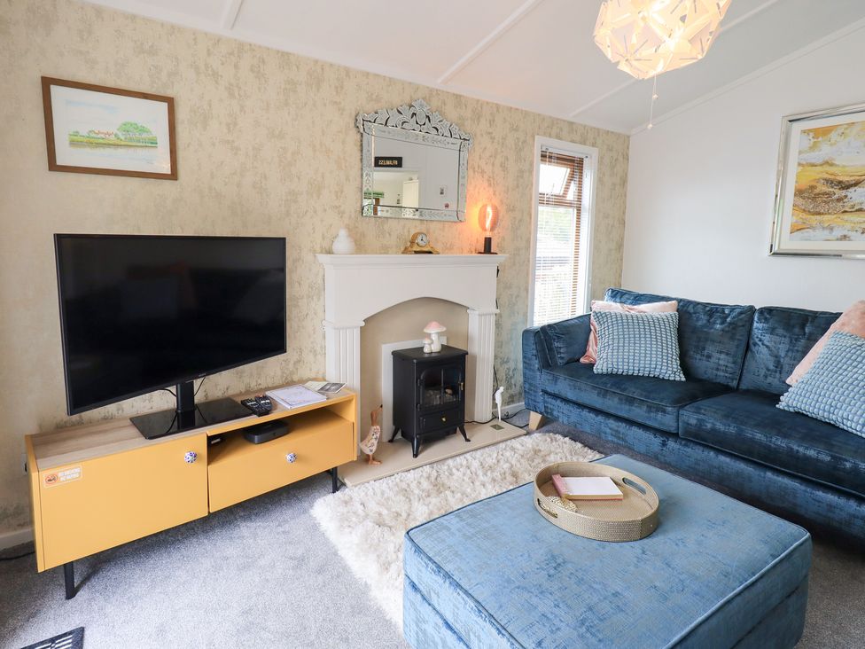 A living room with a television and sofa at Charnwood