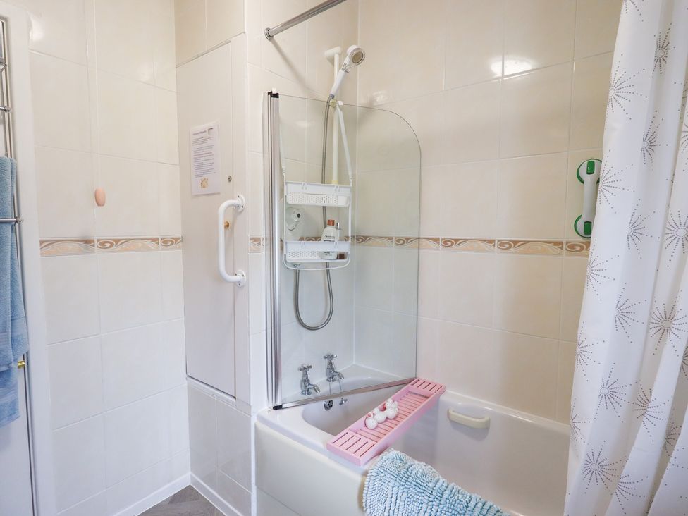 A bathroom with a shower over a bathtub at Charnwood