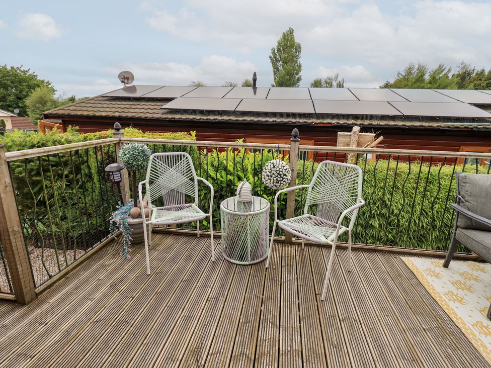 An outdoor patio with two chairs and a table at Charnwood