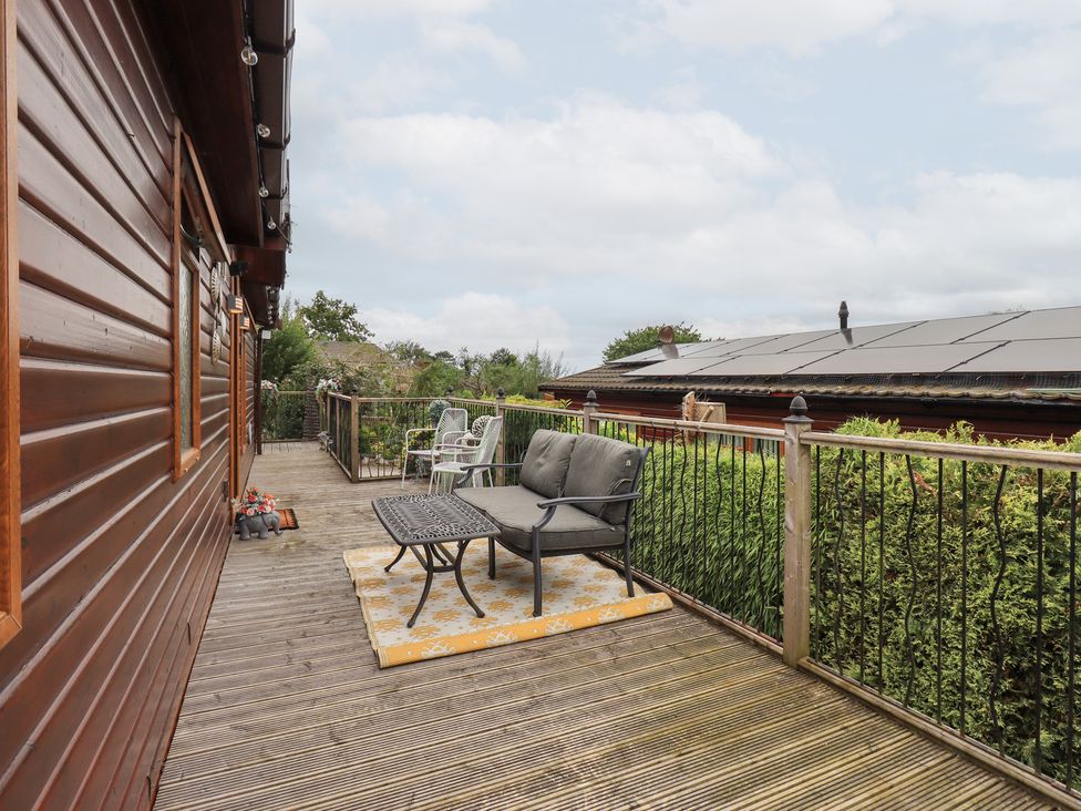 A deck with outdoor seating and a table at Charnwood
