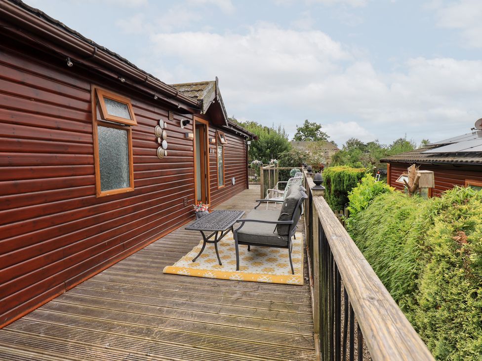 An outdoor deck area with seating and a coffee table at Charnwood