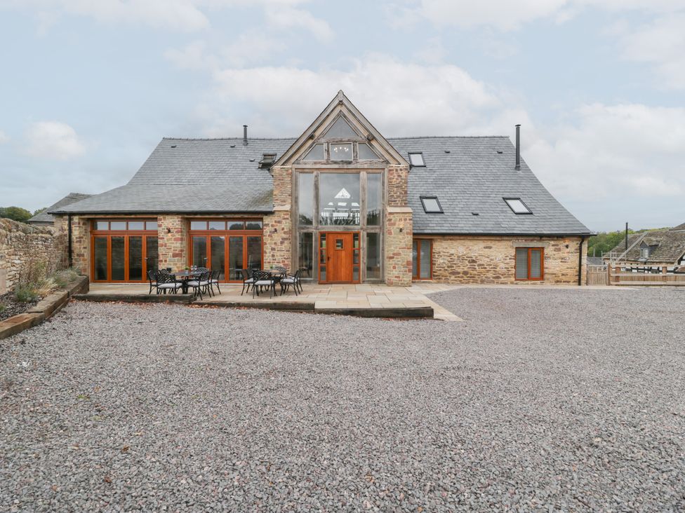 An outdoor area with a house and patio furniture at Two Parks Barn Upton Bishop near Ross-On-Wye