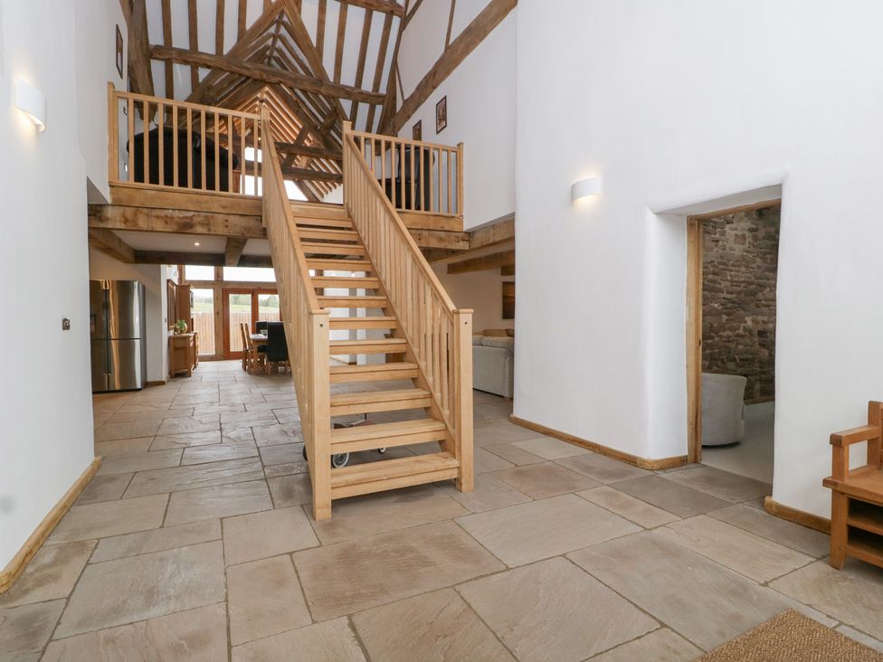 An entrance hall with a staircase and kitchen table at Two Parks Barn Upton Bishop near Ross-On-Wye