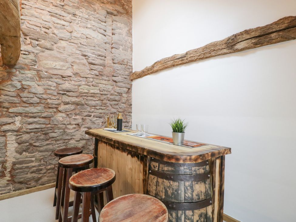 A bar area with wooden countertop and stools at Two Parks Barn Upton Bishop near Ross-On-Wye