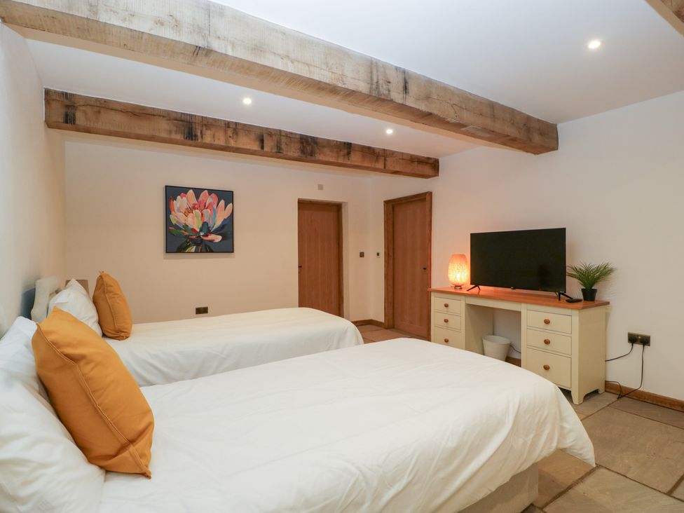 A bedroom with two beds and a television at Two Parks Barn Upton Bishop near Ross-On-Wye