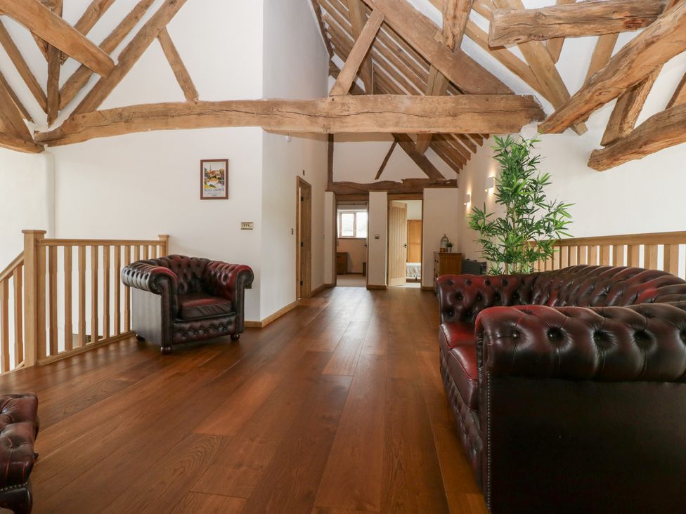A living room with sofas and a staircase at Two Parks Barn in Upton Bishop near Ross-On-Wye