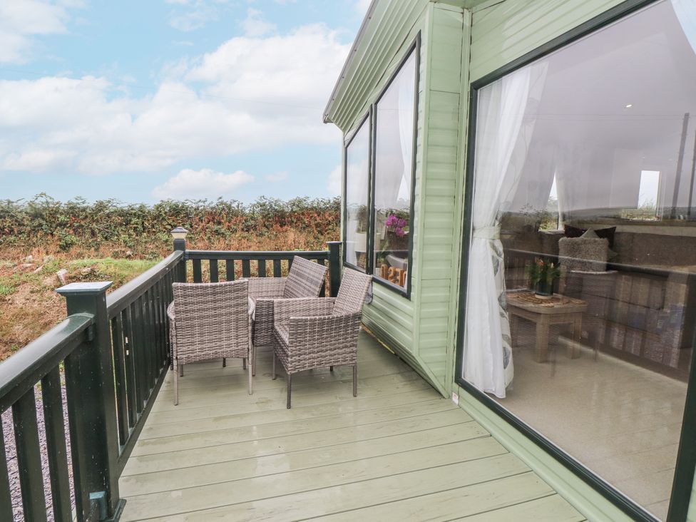A deck with chairs and a table at Bryncrin Edern