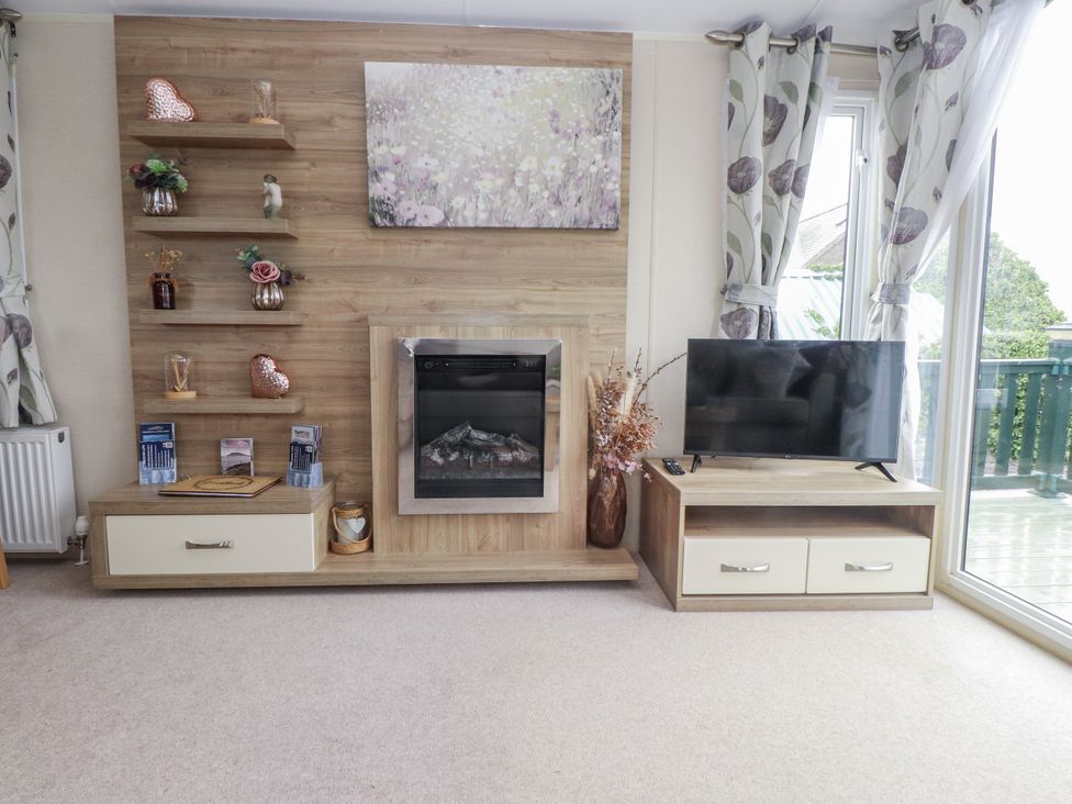 A living room with a fireplace and television at Bryncrin in Edern