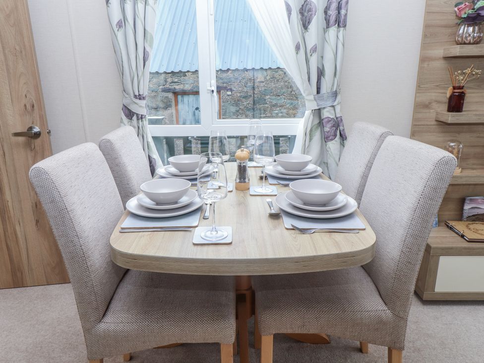 A dining room with a table set for four at Bryncrin Edern