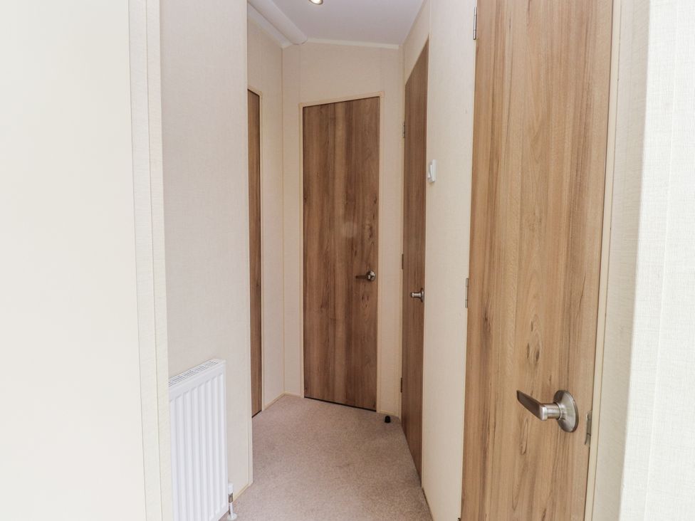 A hallway with doors and a radiator at Bryncrin Edern