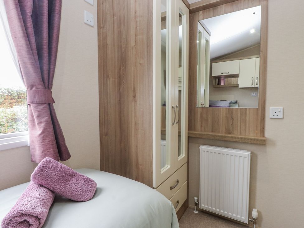 A bedroom with a wardrobe and mirror at Bryncrin in Edern