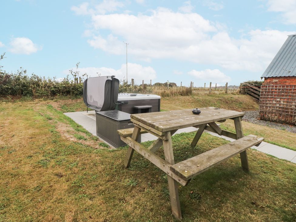 A garden with a hot tub and picnic table at Bryncrin Edern
