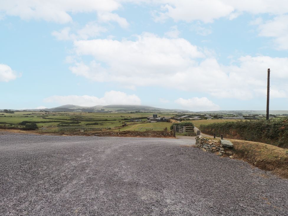 A view of a gravel driveway leading to fields and mountains at Bryncrin in Edern