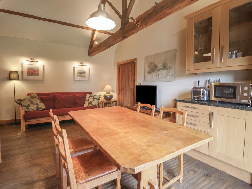 A dining room with a wooden table and chairs at The Annex at Manor Farm