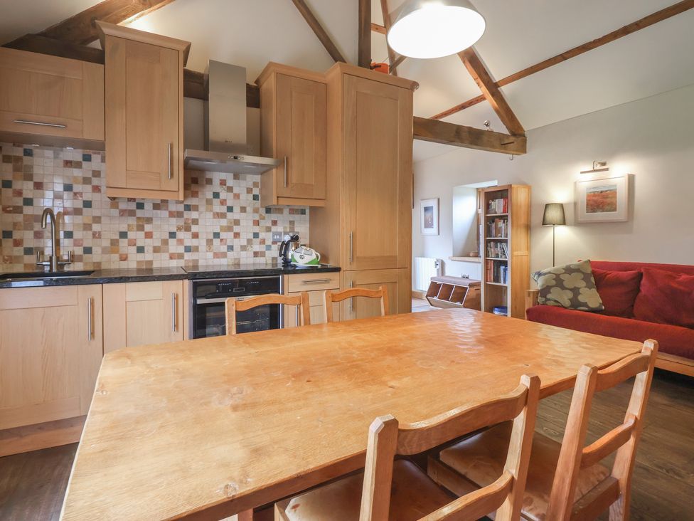 A kitchen and dining area with wooden table and chairs at The Annex at Manor Farm