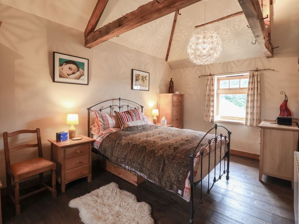 A bedroom with a bed and wooden furniture at The Annex at Manor Farm