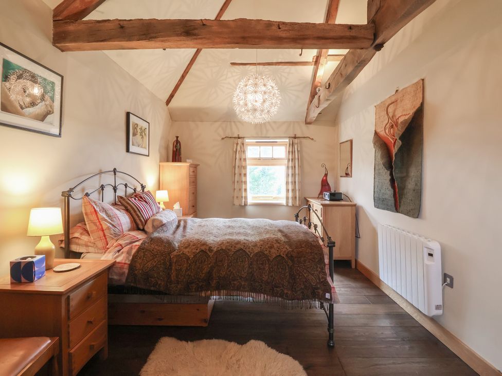 A bedroom with a bed and wooden furniture at The Annex at Manor Farm