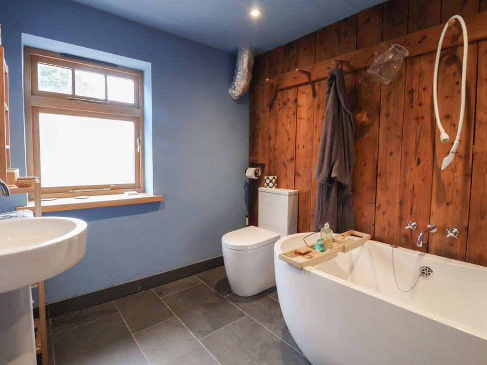 A bathroom with a bathtub, toilet, and sink at The Annex at Manor Farm