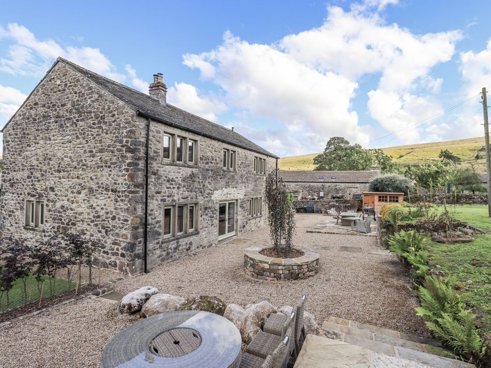 A stone house with garden and patio furniture at Hallbeck near Kettlewell
