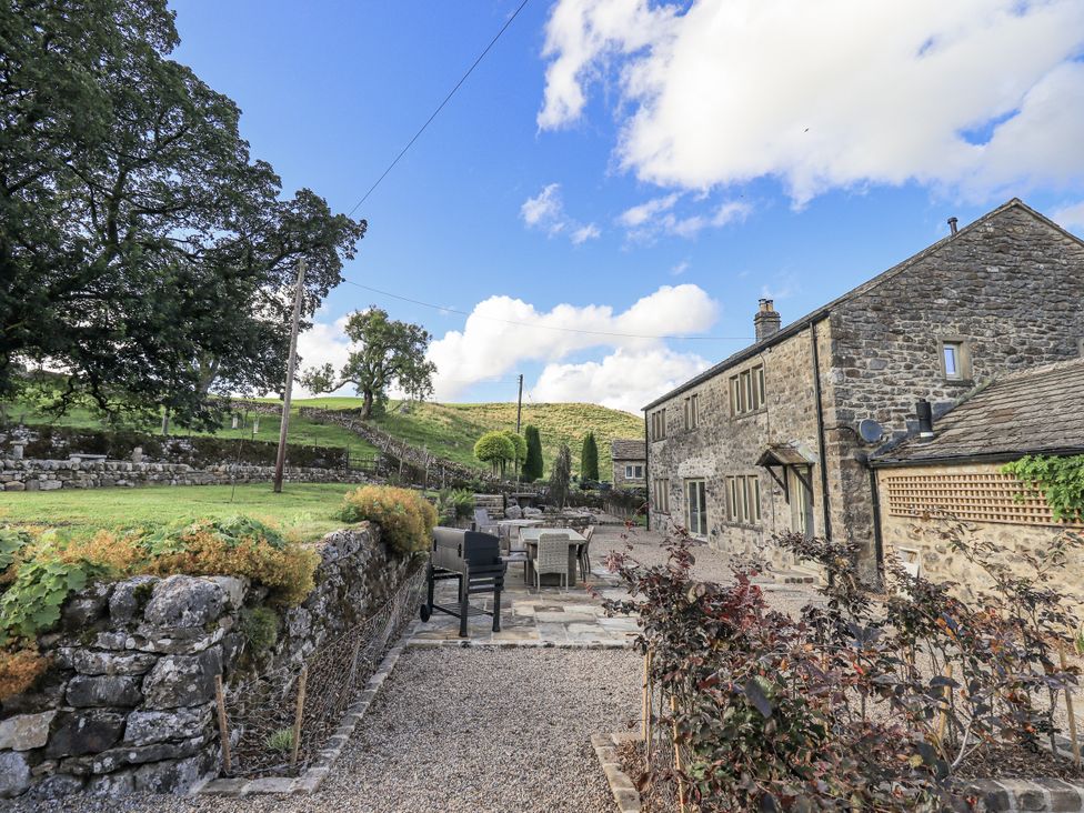 An outdoor area with a house, furniture, garden and trees at Hallbeck near Kettlewell