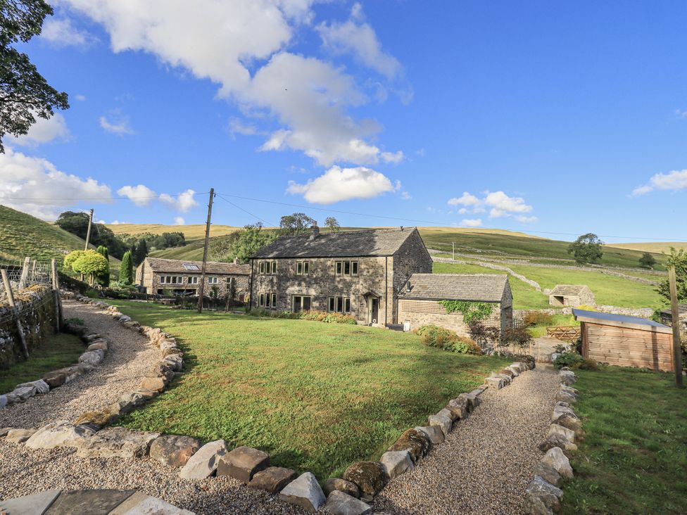 An outdoor view of a house with a garden at Hallbeck near Kettlewell