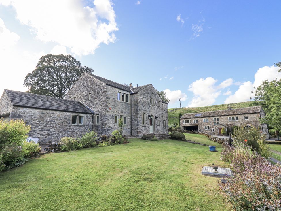 A stone house with a garden and a pathway at Hallbeck near Kettlewell