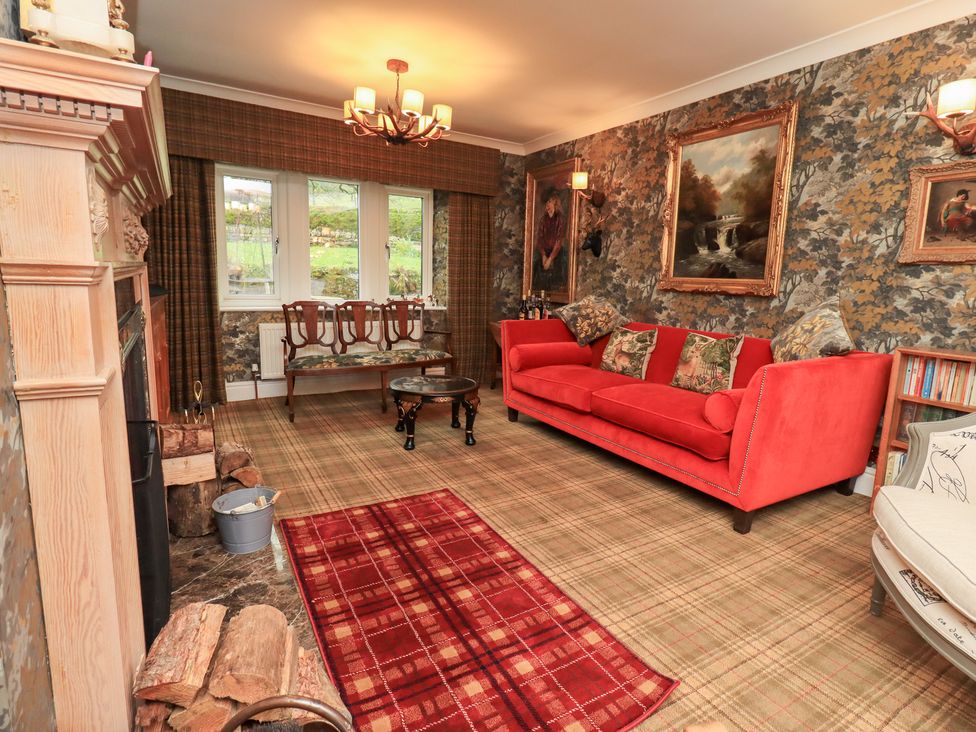 A living room with a sofa and fireplace at Hallbeck in Buckden