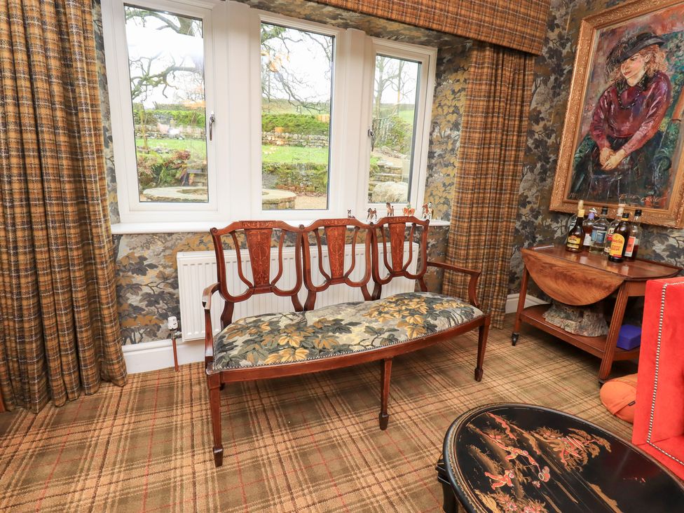 A sitting room with a bench and windows at Hallbeck in Buckden