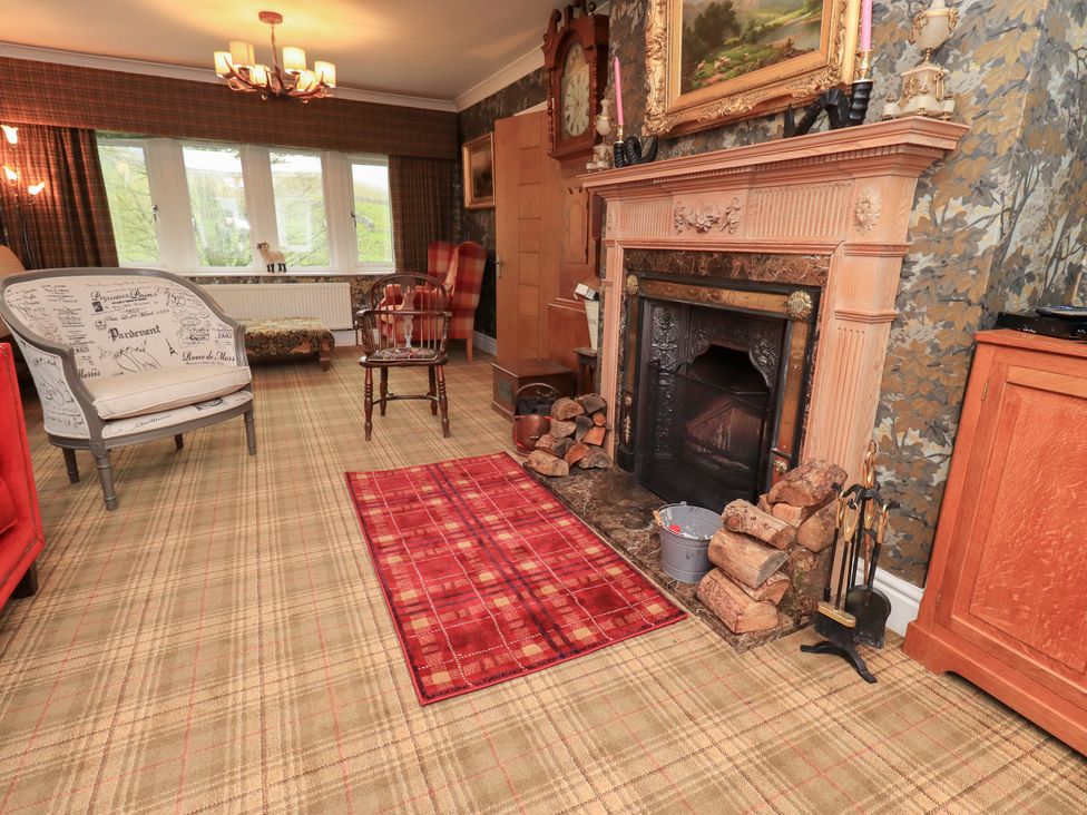 A living room with a fireplace and seating area at Hallbeck in Buckden