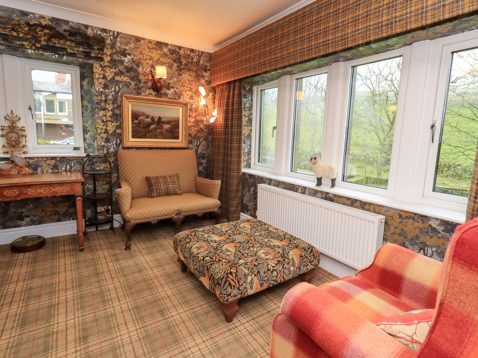 A living room with a sofa and armchair at Hallbeck in Buckden