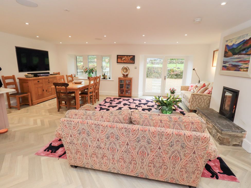A living room with a sofa and dining area at Hallbeck in Buckden