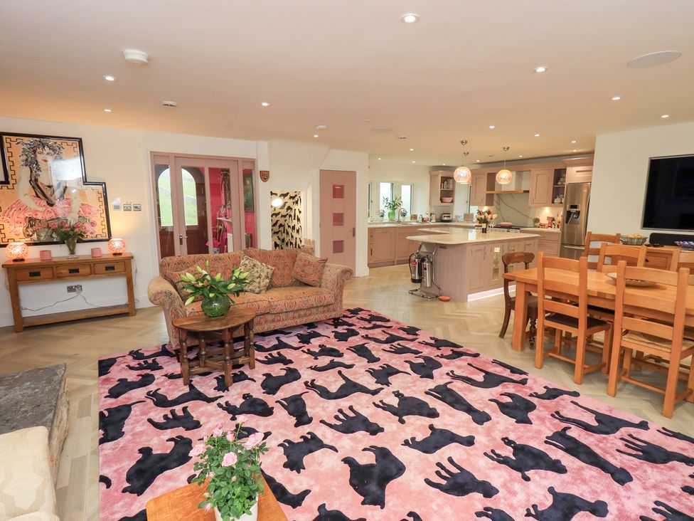 An open plan living area with a sofa coffee table and dining table at Hallbeck Buckden