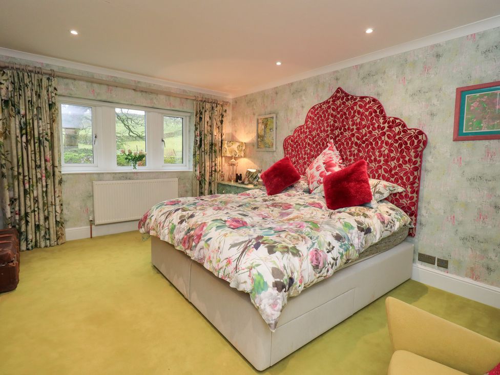 A bedroom with a large bed and windows at Hallbeck in Buckden