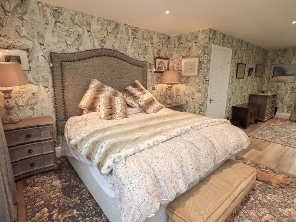 A bedroom with a large bed and side tables at Hallbeck in Buckden