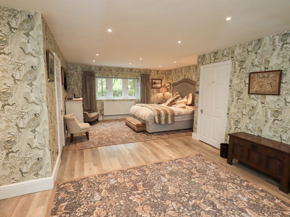 A bedroom with a bed and seating area at Hallbeck in Buckden