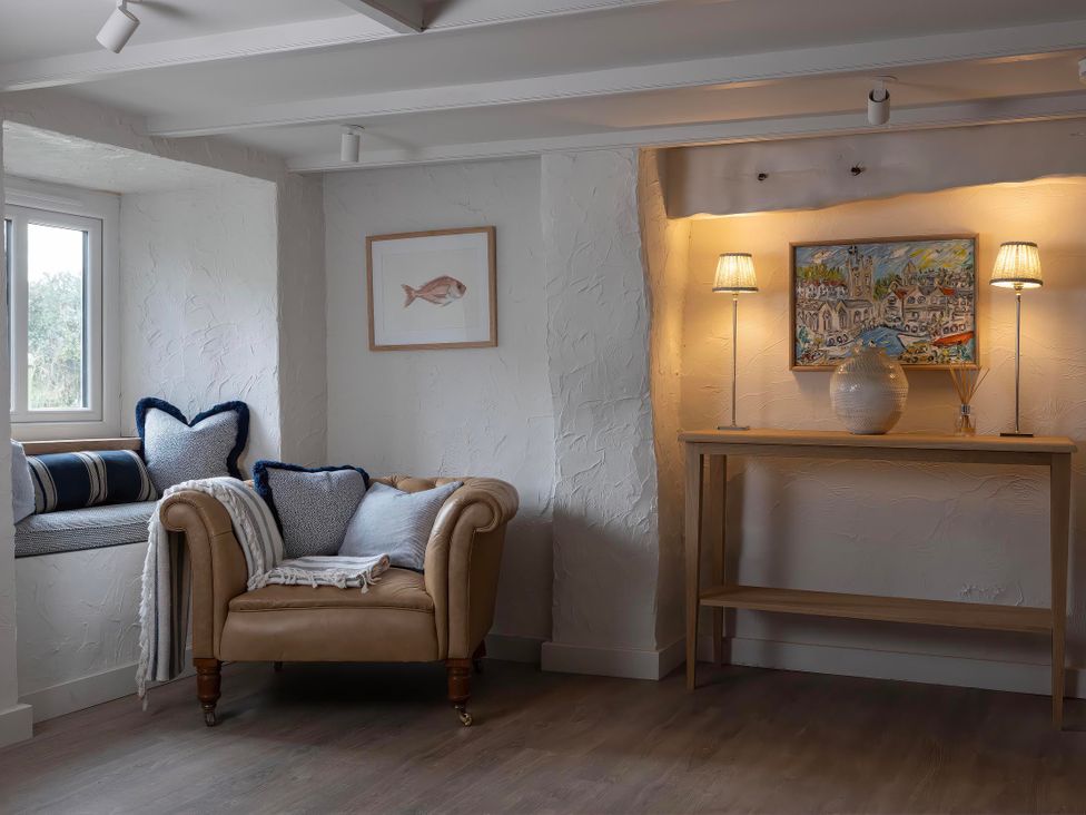 A living room with a sofa and a painting at Rose Cottage in Wadebridge