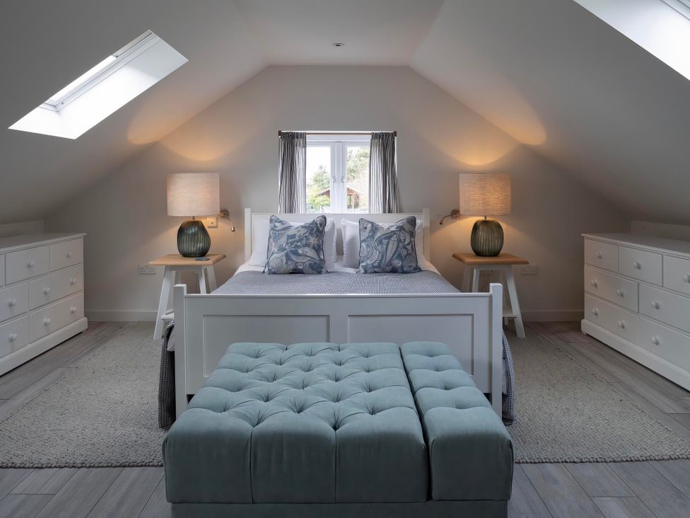 A bedroom with a bed and dressers at Rose Cottage in Wadebridge
