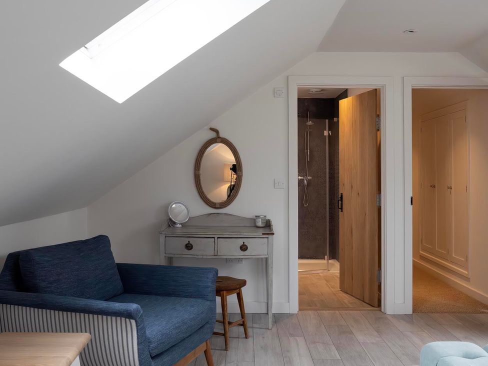 A bedroom with a sofa and a shower at Rose Cottage in Wadebridge