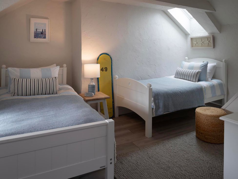 A bedroom with two beds and a lamp at Rose Cottage in Wadebridge