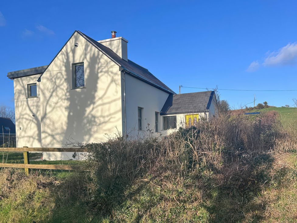 A house with windows and a roof in a field at Knocknanuss