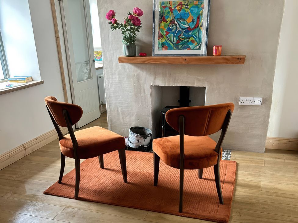 A living room with chairs and a fireplace at Knocknanuss