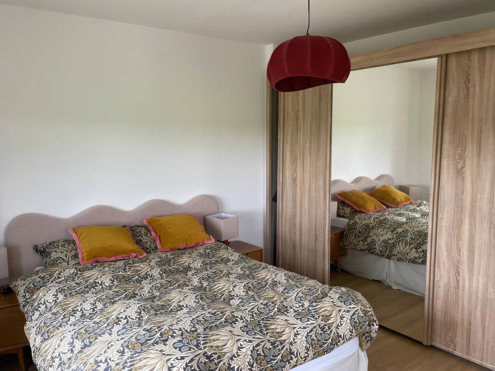 A bedroom with a bed and a mirror wardrobe at Knocknanuss in 