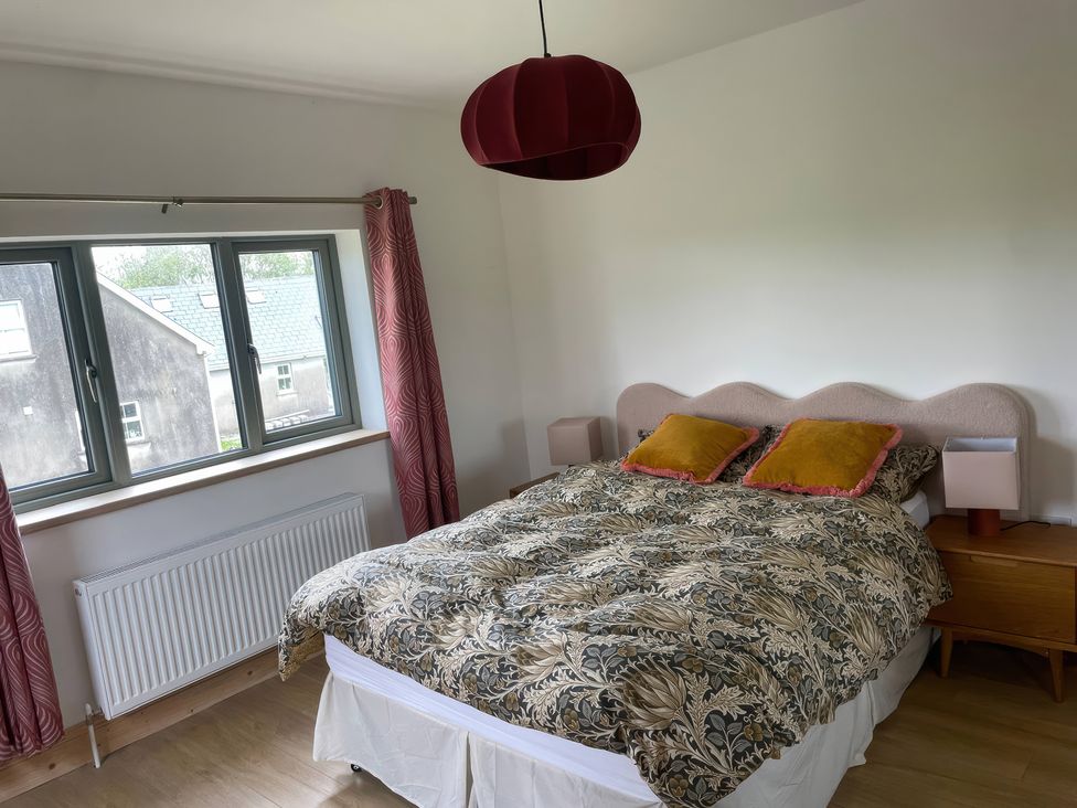 A bedroom with a bed and two windows at Knocknanuss