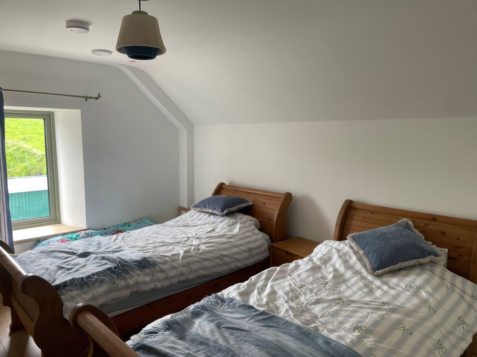 A bedroom with two beds and a window at Knocknanuss
