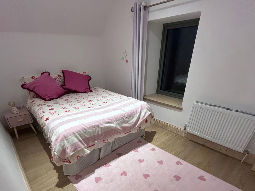 A bedroom with a bed and nightstand at Knocknanuss