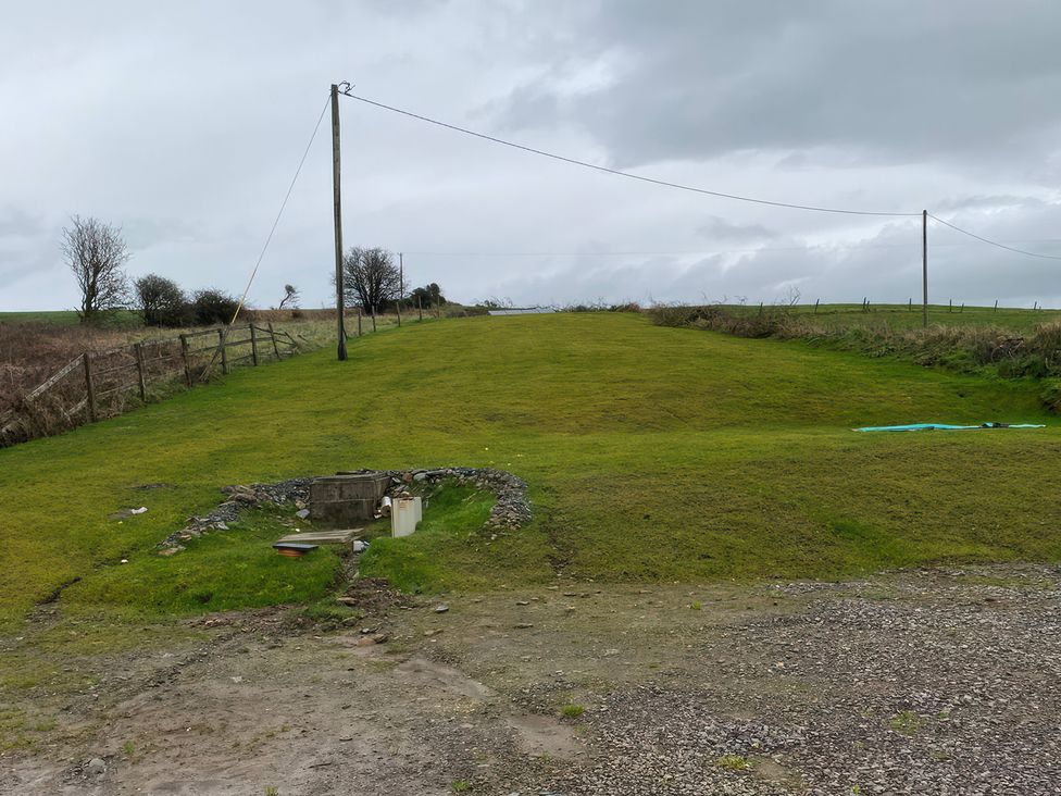 An outdoor area with a grassy field and a water source at Knocknanuss
