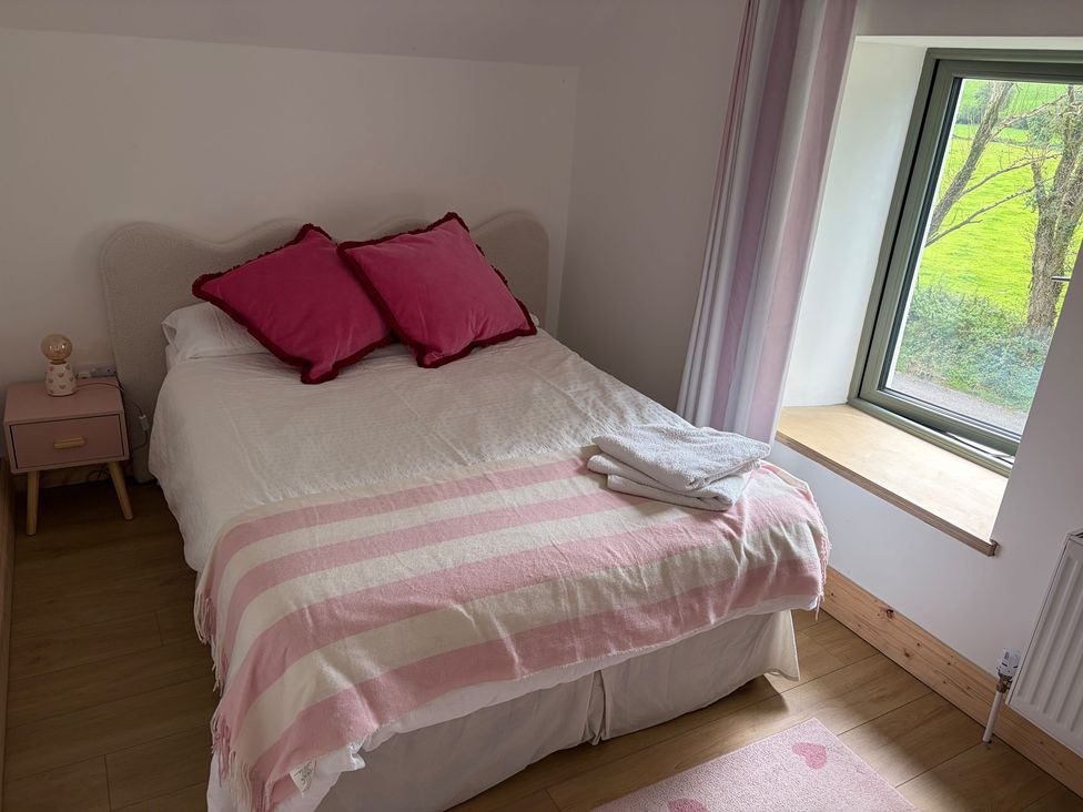 A bedroom with bed and nightstand at Knocknanuss Ballinascarty County Cork