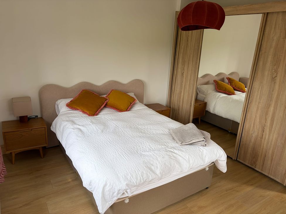A bedroom with a bed and bedside lamp at Knocknanuss, Ballinascarty, County Cork