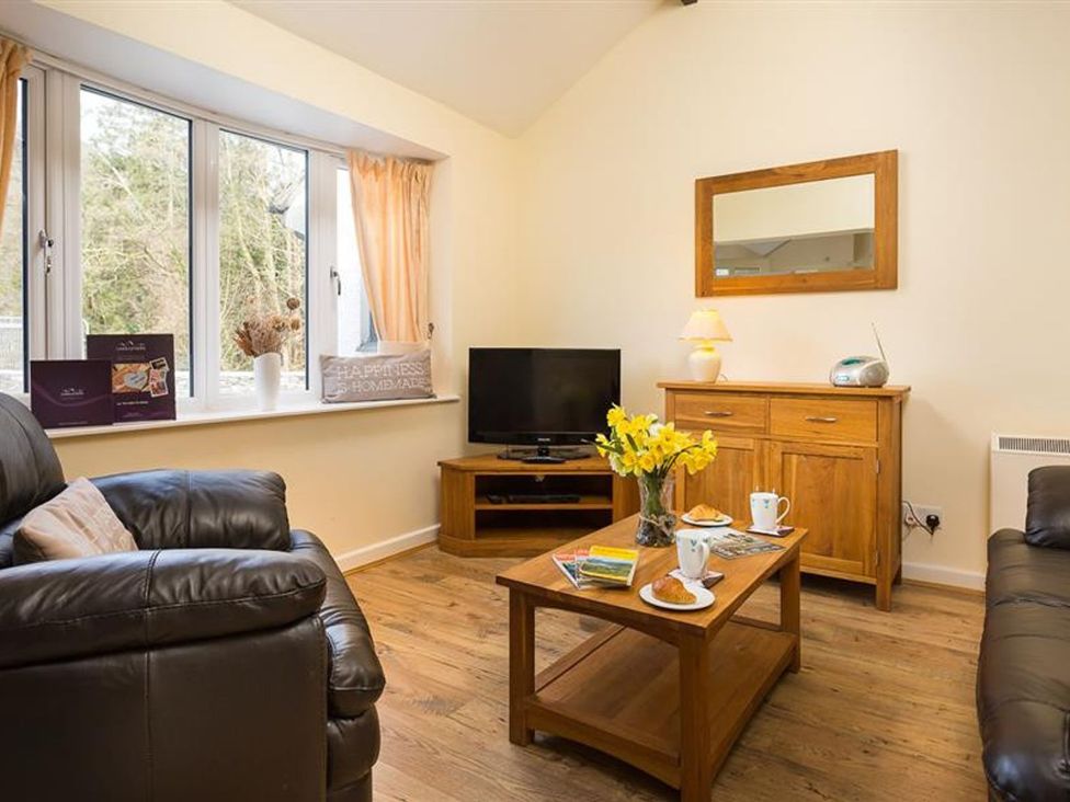 A living room with a sofa and coffee table at 2 Riverside Cottages Ambleside